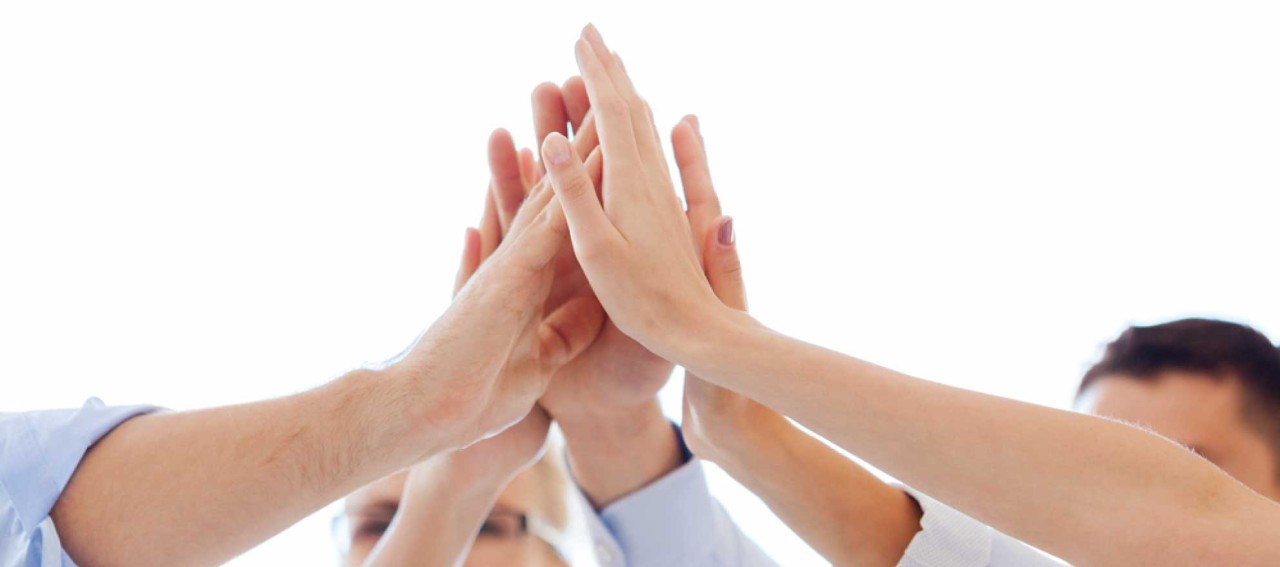 Varias manos chocando en círculo